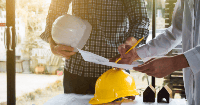 Tecnici con casco che verificano un progetto edilizio