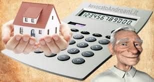Mani che sorreggono una casetta accanto a una calcolatrice