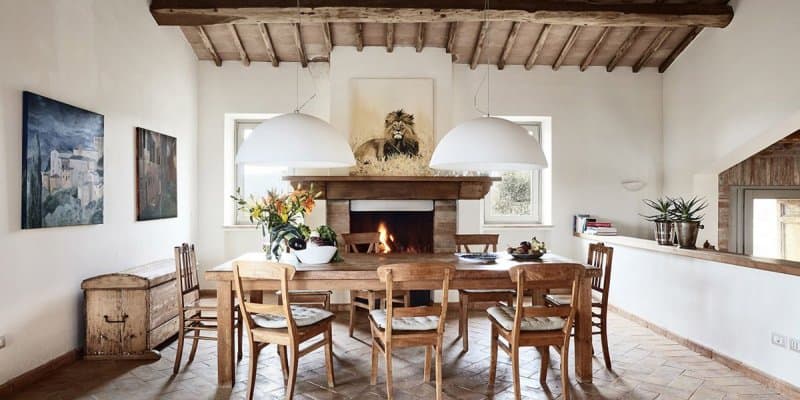 Interno di un casale toscano con travi a vista e camino